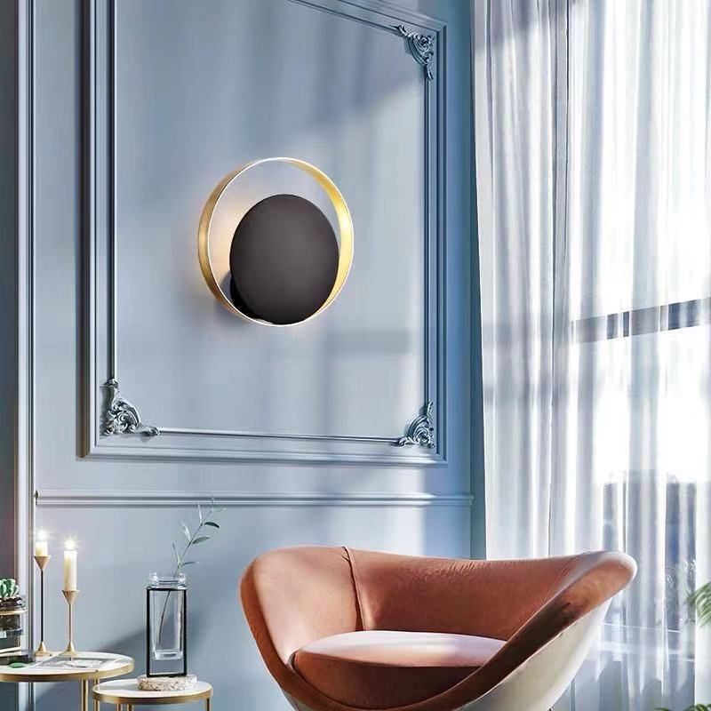 Lampada a parete circolare nera e oro nella moderna semplicità della parete in ferro battuto per gli spazi interni