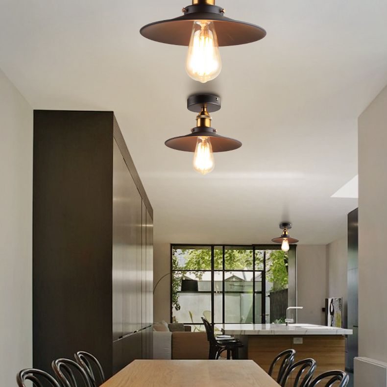 Ristorante industriale in metallo con lampada da soffitto a cono nero vicino all'illuminazione a soffitto