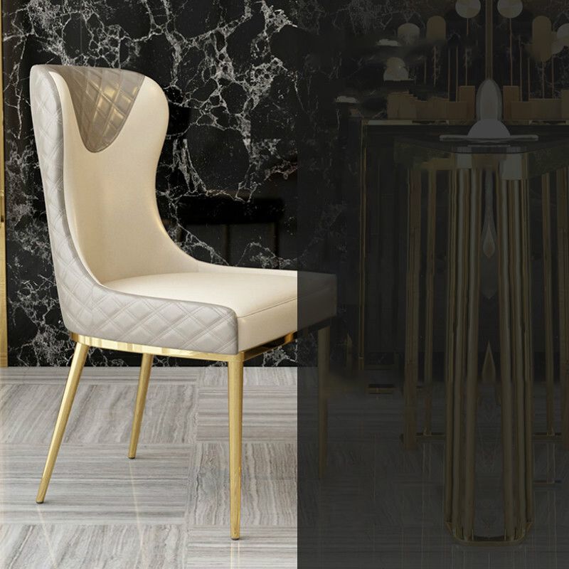 Silla sin brazos tapizada de cuero con respaldo lateral y patas de metal