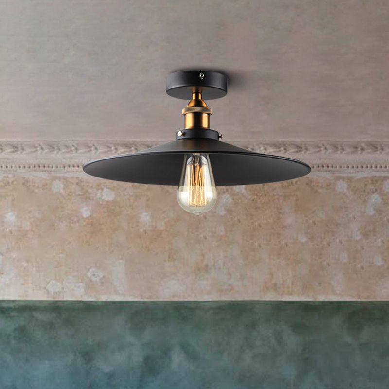 Ristorante industriale in metallo con lampada da soffitto a cono nero vicino all'illuminazione a soffitto
