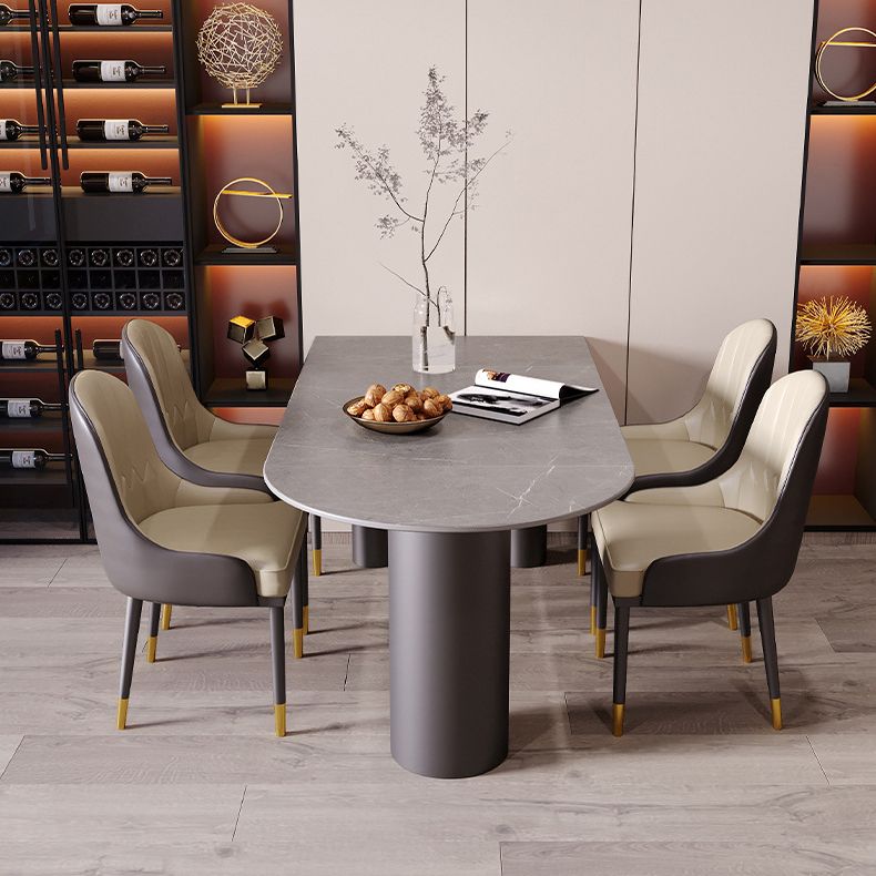 Tavolo da pranzo moderno con piano in pietra e base in acciaio nero