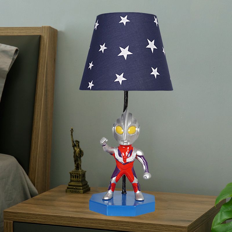 Lampada da tavolo blu a botte/trapezio per bambini, illuminazione da comodino in tessuto a 1 testa con decorazione Ultraman