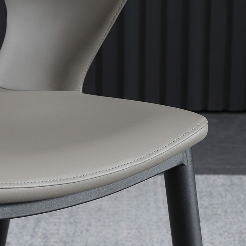 Silla de comedor contemporánea de cuero con respaldo abierto y patas negras