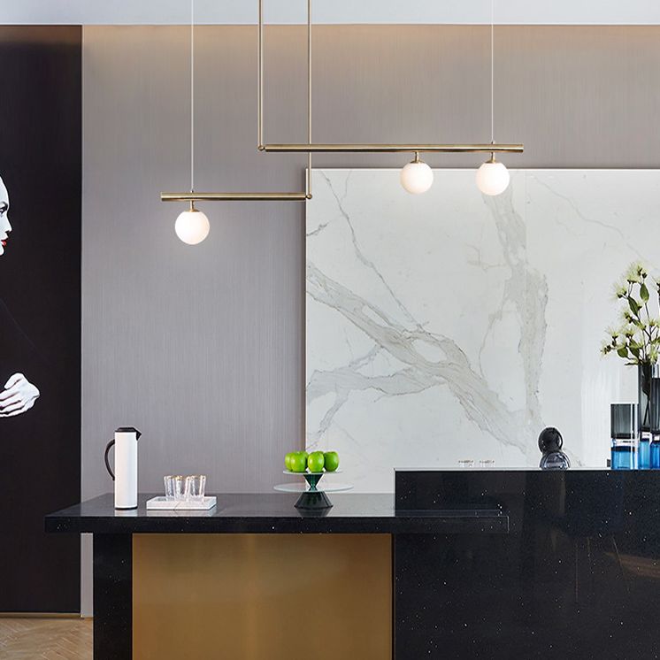 Minimalismo moderno Gold Metal Isola lineare Accensione a sospensione Globe Glass Island Affermazione Luce per soggiorno