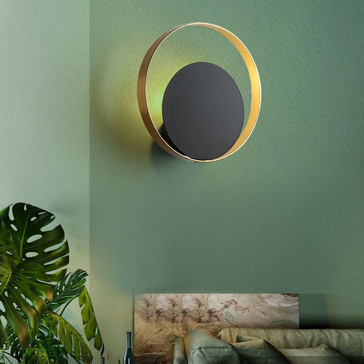 Lampada a parete circolare nera e oro nella moderna semplicità della parete in ferro battuto per gli spazi interni