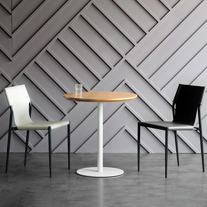 El comedor de cuero industrial preside el metal sin brazos que cena las sillas para el uso del restaurante