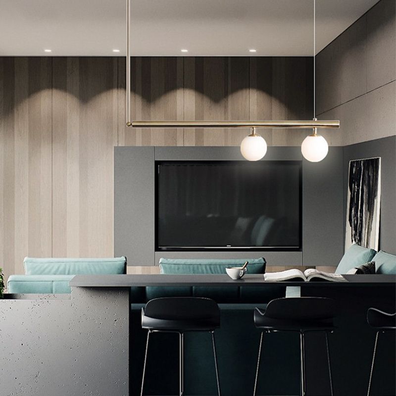 Minimalismo moderno Gold Metal Isola lineare Accensione a sospensione Globe Glass Island Affermazione Luce per soggiorno