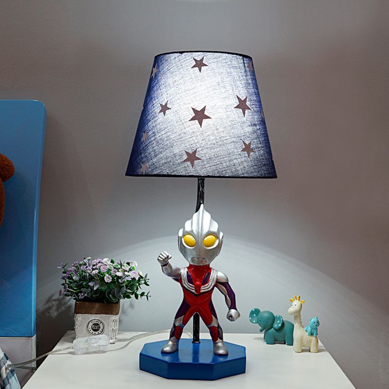Lampada da tavolo blu a botte/trapezio per bambini, illuminazione da comodino in tessuto a 1 testa con decorazione Ultraman