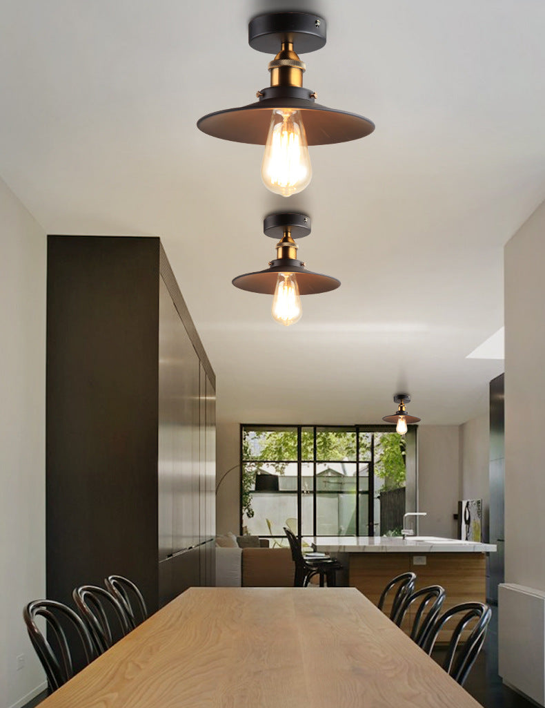 Ristorante industriale in metallo con lampada da soffitto a cono nero vicino all'illuminazione a soffitto