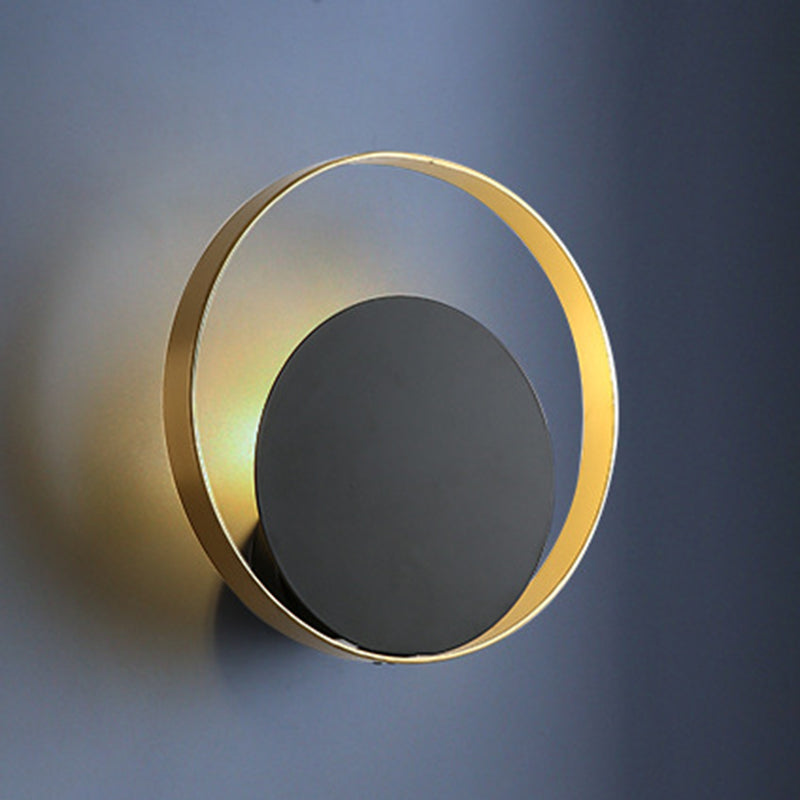 Lampada a parete circolare nera e oro nella moderna semplicità della parete in ferro battuto per gli spazi interni