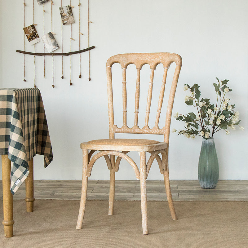 La salle à manger traditionnelle en bois massif préside les chaises à dossier à lamelles de finition mate