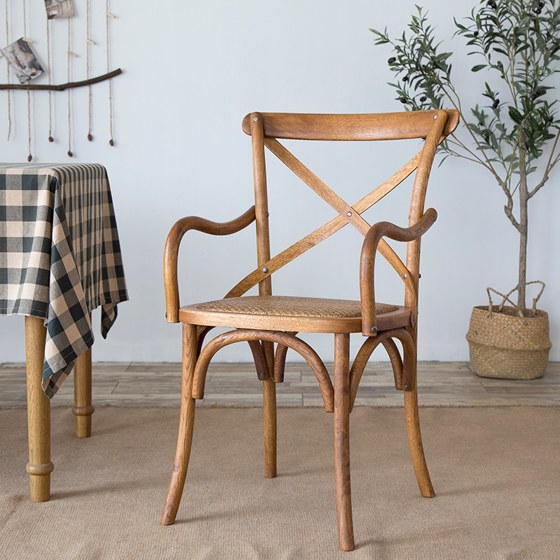 El comedor de madera del cortijo preside los sillones de comedor de mimbre para el uso del restaurante