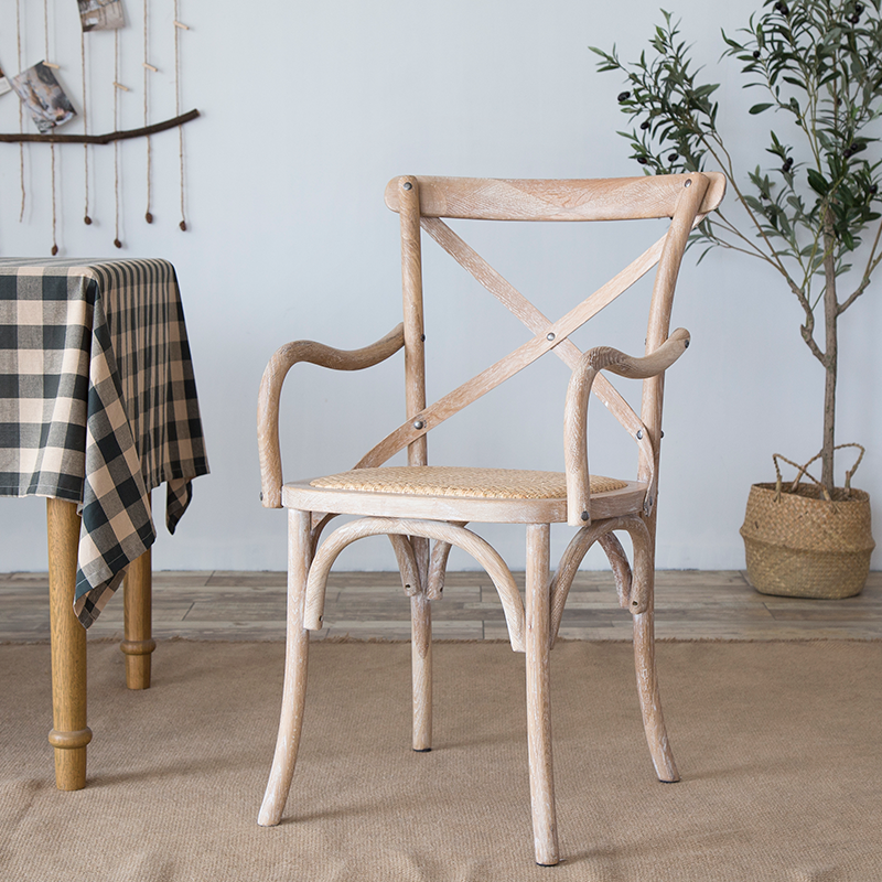El comedor de madera del cortijo preside los sillones de comedor de mimbre para el uso del restaurante