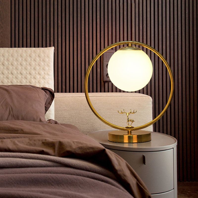Lampada da tavolo a sfera in vetro avorio stile semplice Lampada da notte dorata a 1 luce con anello in metallo e decorazione con cervo