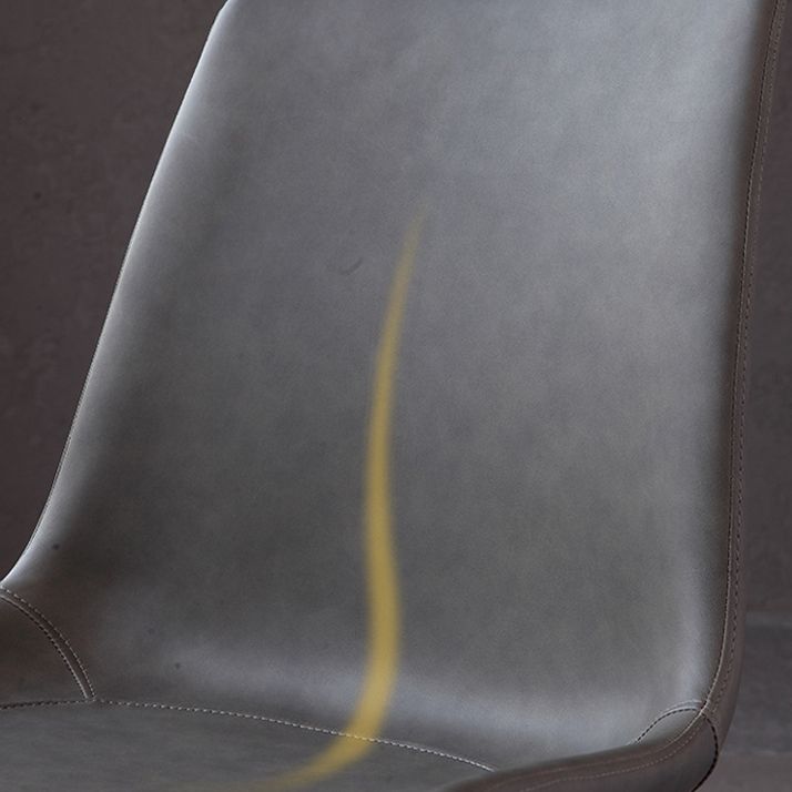 El comedor contemporáneo preside la silla sin brazos curvada de cuero mate de Parsons
