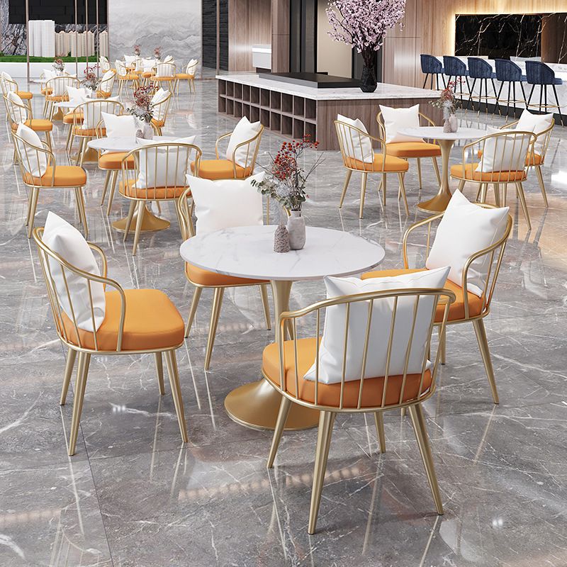 Salle de salle à manger blanche en pierre glamour avec table ronde et meubles de table à manger de base en métal