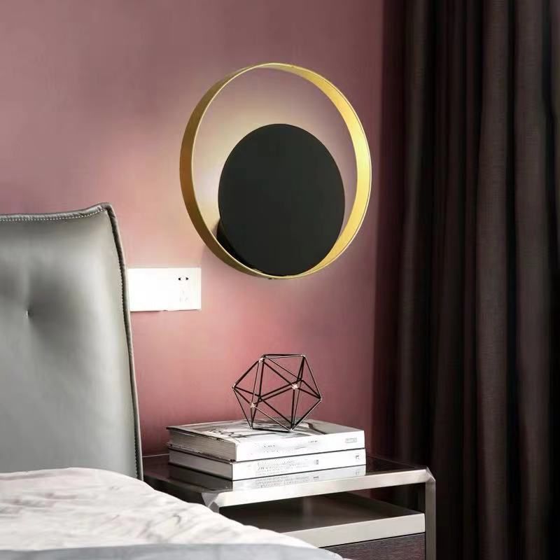 Lampada a parete circolare nera e oro nella moderna semplicità della parete in ferro battuto per gli spazi interni