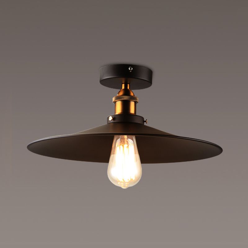 Ristorante industriale in metallo con lampada da soffitto a cono nero vicino all'illuminazione a soffitto
