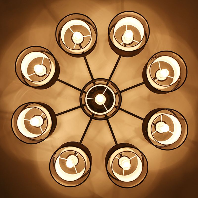 Soggiorno contemporaneo in tessuto cilindrico semifulto vicino al lampadario del soffitto in nero