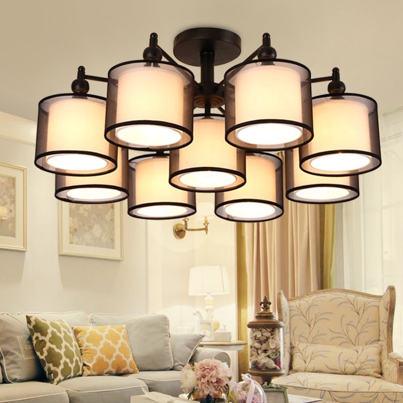 Soggiorno contemporaneo in tessuto cilindrico semifulto vicino al lampadario del soffitto in nero