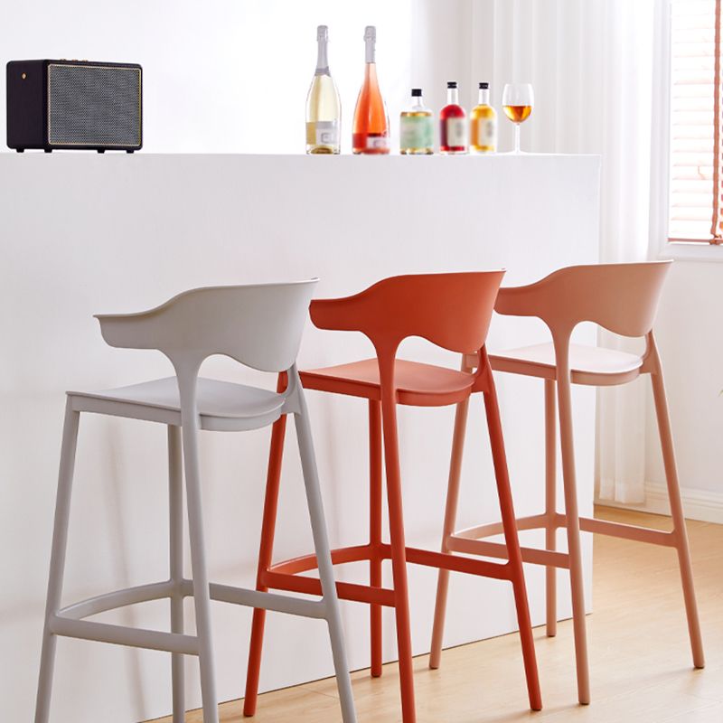 Taburetes de bar escandinavos de plástico apilables para interiores con respaldo bajo y reposapiés