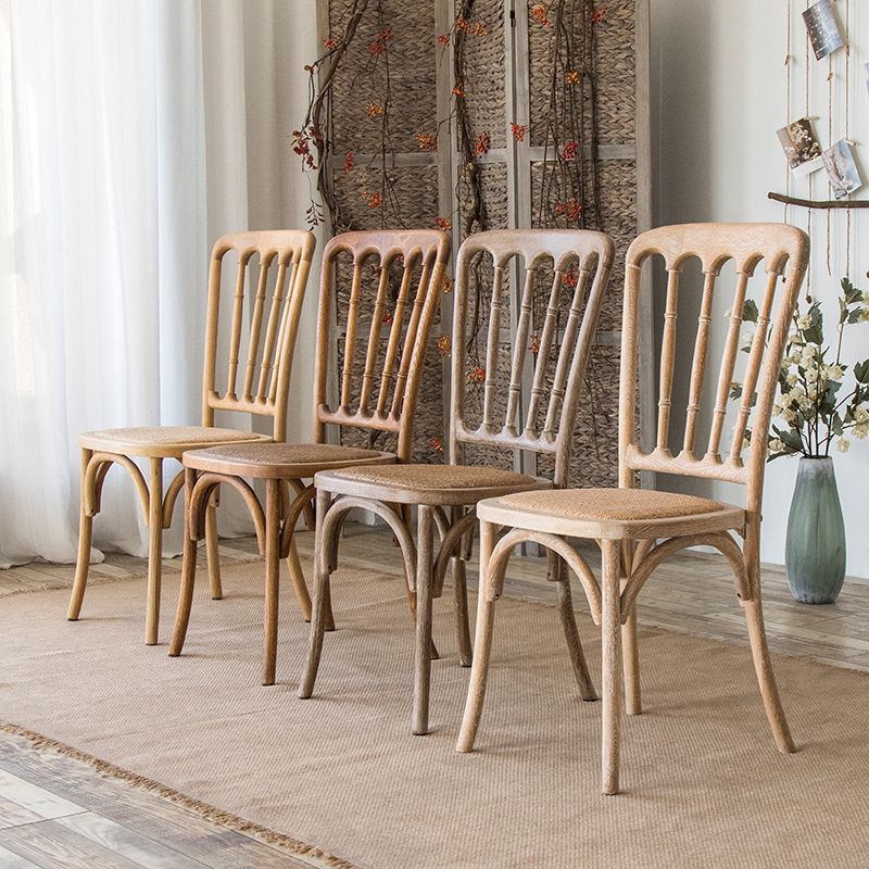 La salle à manger traditionnelle en bois massif préside les chaises à dossier à lamelles de finition mate
