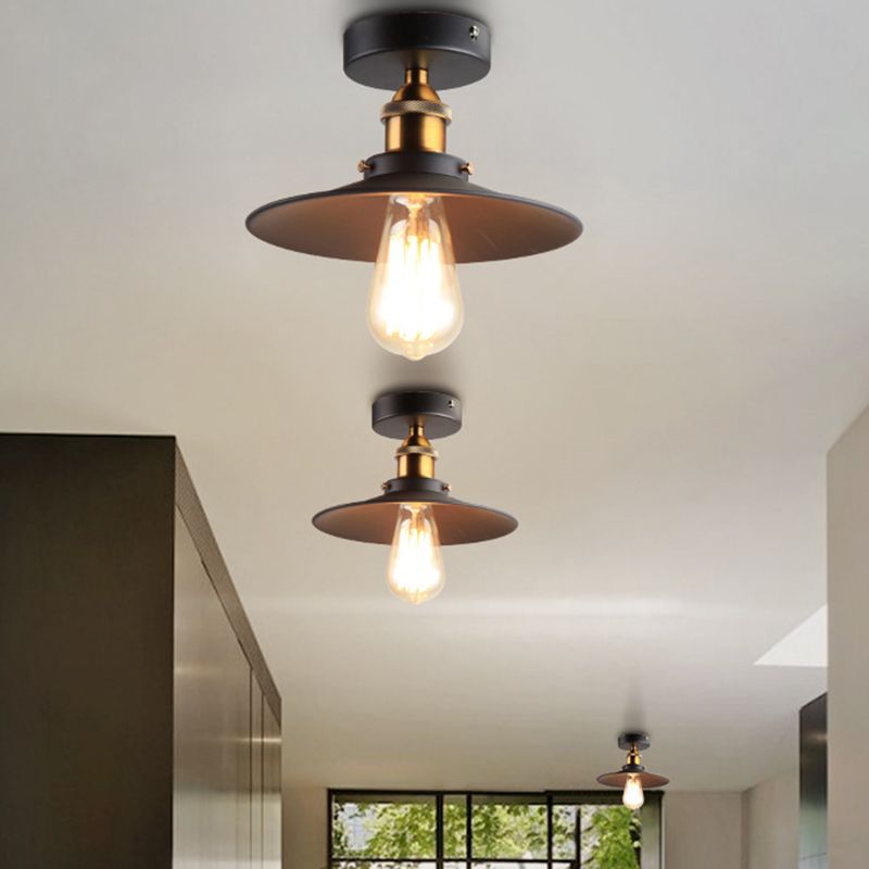 Ristorante industriale in metallo con lampada da soffitto a cono nero vicino all'illuminazione a soffitto