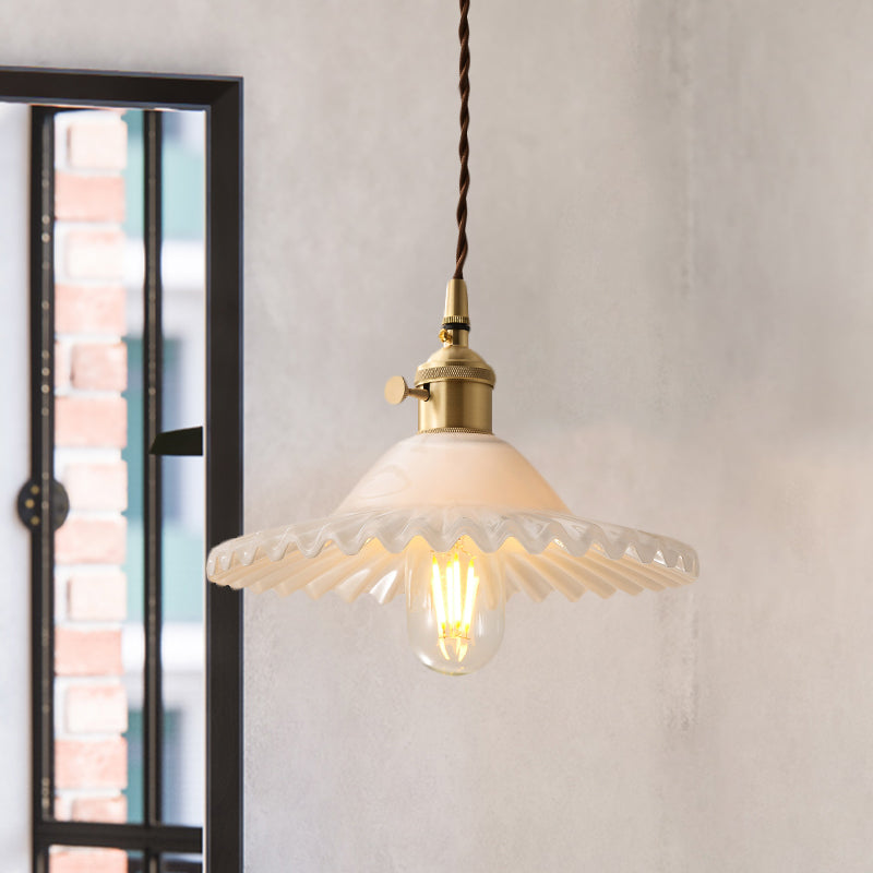Un dispositivo di illuminazione a sospensione leggera affascinato in ottone industriale vetro bianco appeso al soffitto