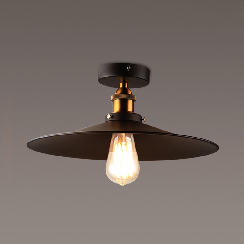 Ristorante industriale in metallo con lampada da soffitto a cono nero vicino all'illuminazione a soffitto