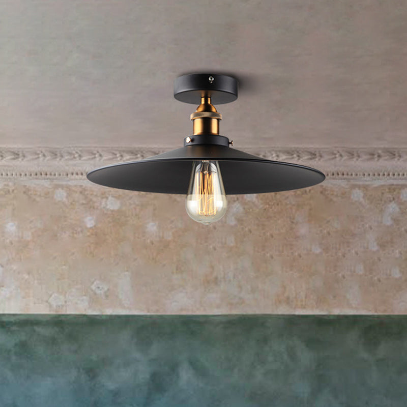 Ristorante industriale in metallo con lampada da soffitto a cono nero vicino all'illuminazione a soffitto