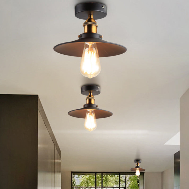 Ristorante industriale in metallo con lampada da soffitto a cono nero vicino all'illuminazione a soffitto
