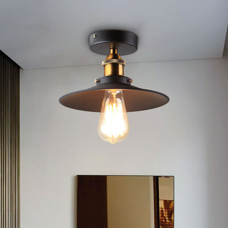 Ristorante industriale in metallo con lampada da soffitto a cono nero vicino all'illuminazione a soffitto