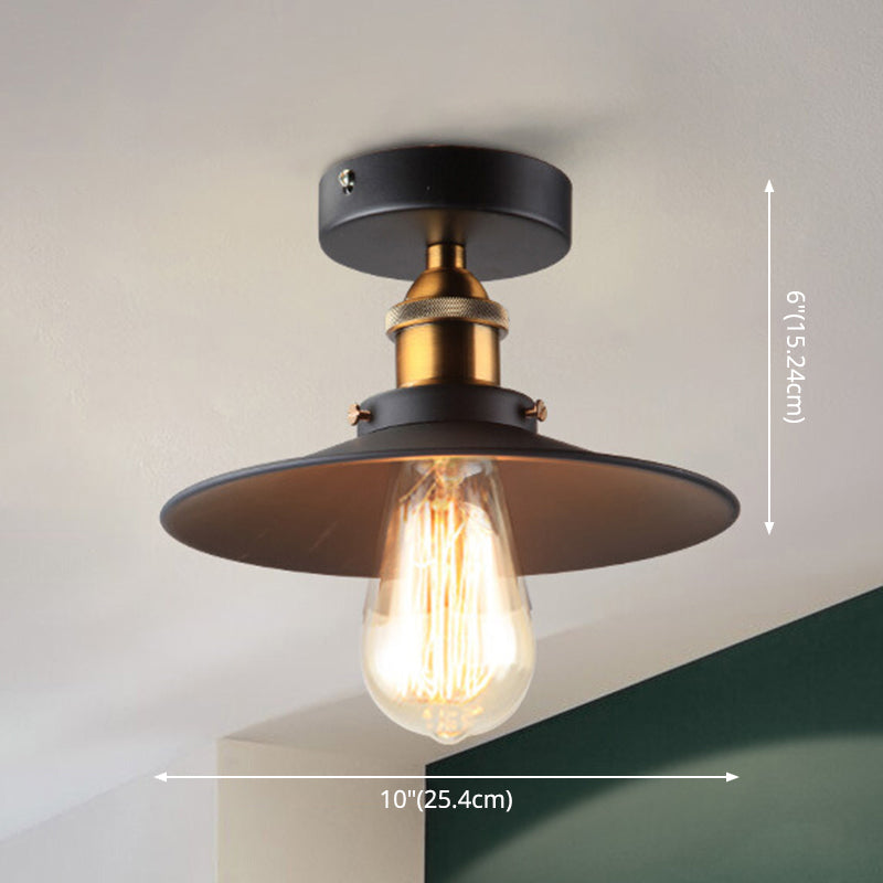 Ristorante industriale in metallo con lampada da soffitto a cono nero vicino all'illuminazione a soffitto