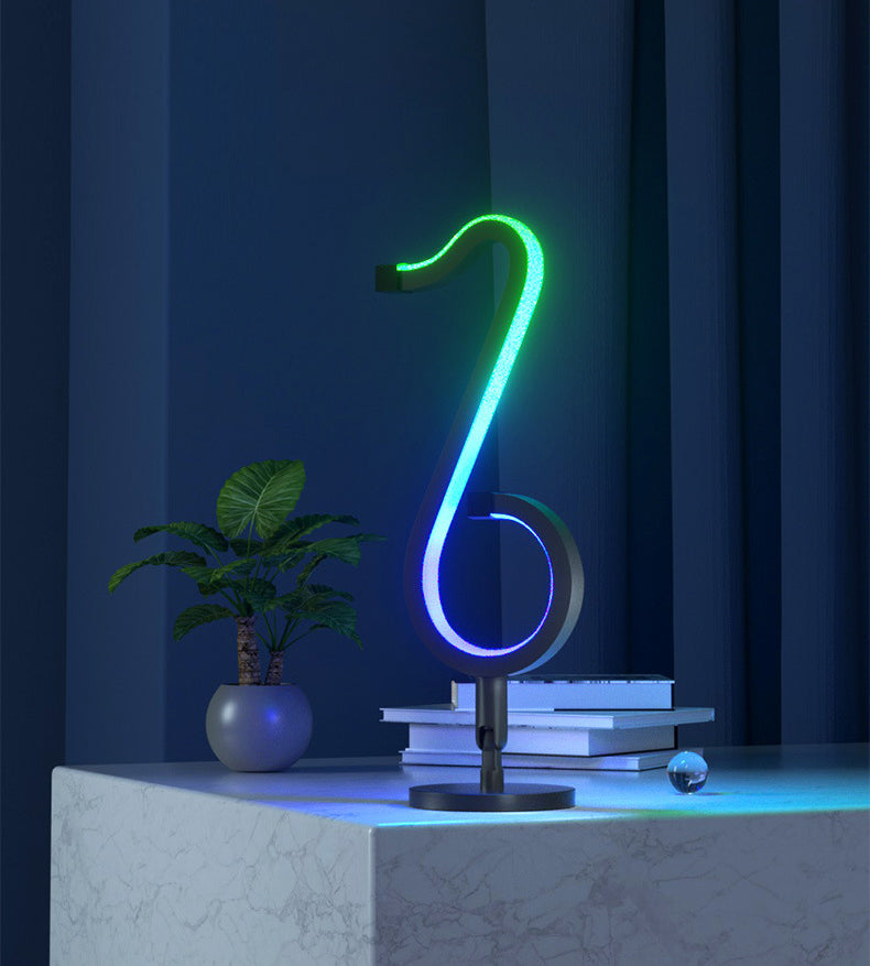 Lampada da tavolo a forma di nota musicale in metallo. Luce notturna a LED nera minimalista alla moda per camera da letto