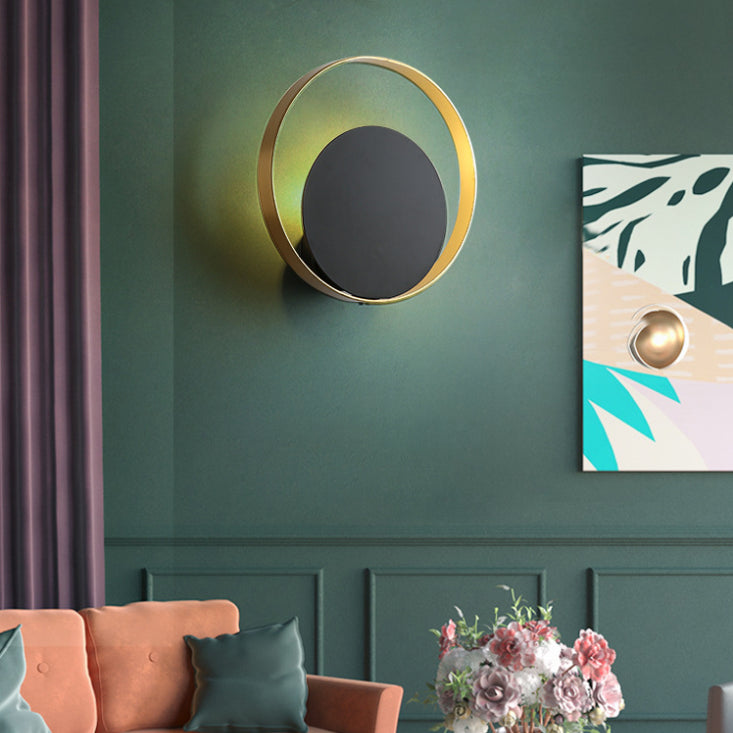 Lampada a parete circolare nera e oro nella moderna semplicità della parete in ferro battuto per gli spazi interni