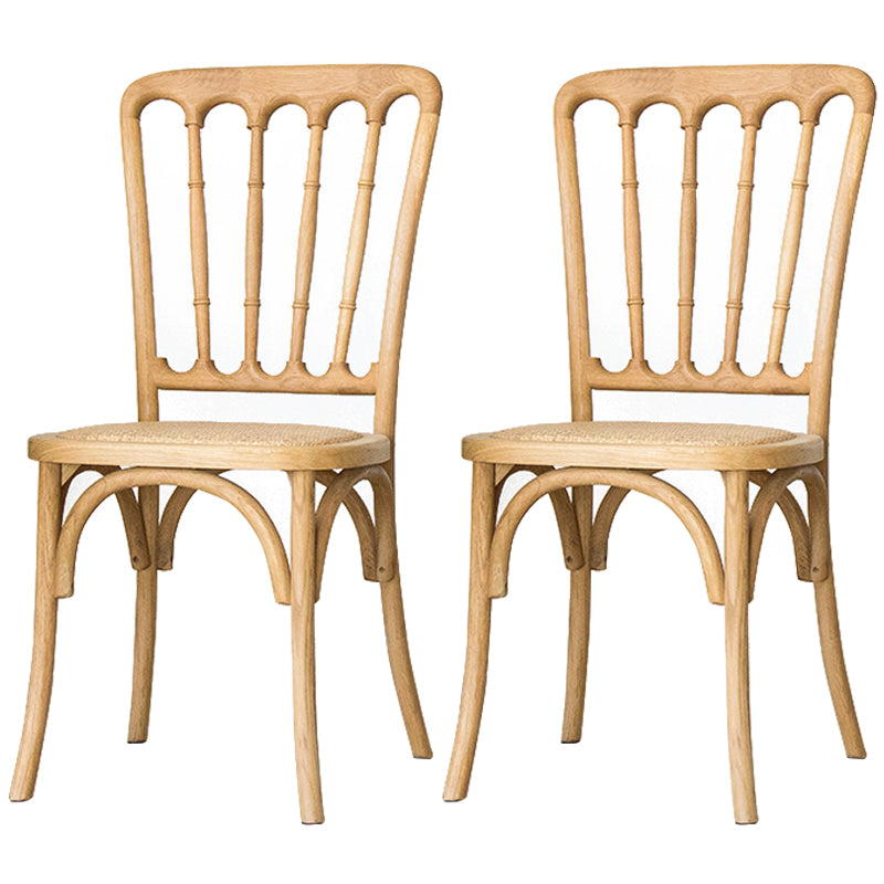 La salle à manger traditionnelle en bois massif préside les chaises à dossier à lamelles de finition mate