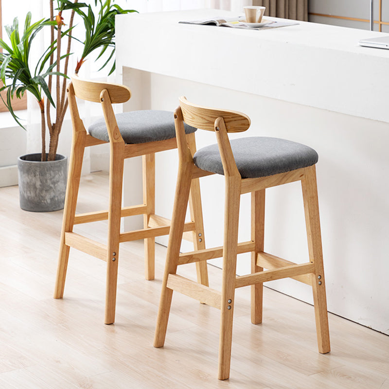 Moderner, armloser Thekenhocker aus Holz mit Rückenlehne und Kissen für den Milchteeladen