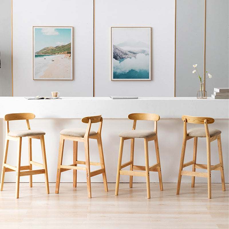 Moderner, armloser Thekenhocker aus Holz mit Rückenlehne und Kissen für den Milchteeladen