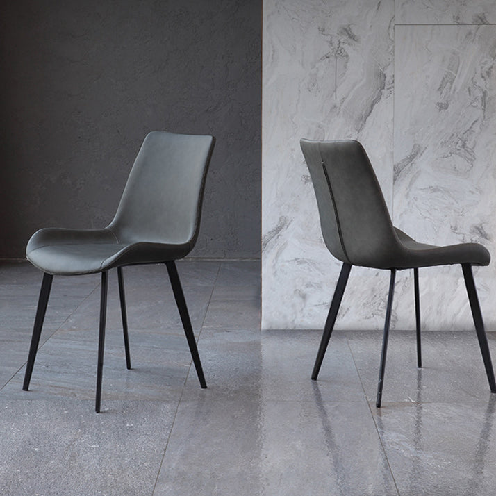 El comedor contemporáneo preside la silla sin brazos curvada de cuero mate de Parsons