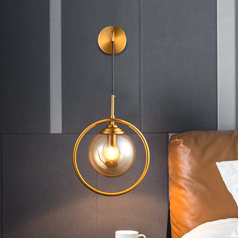 Metal Ring Sconce Lighting Modern 1-Bulb Brass Wall Mounted Lamp with Sphere Tan Glass Shade for Bedside