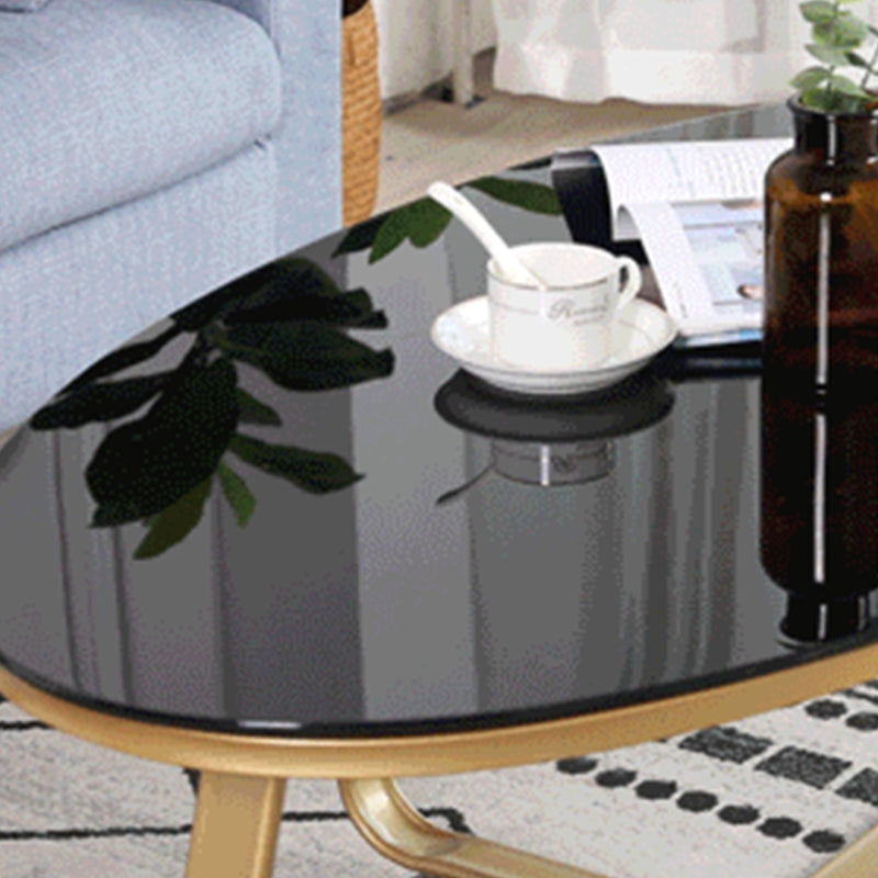 Glam Style Cocktail Table with Oval Top and Golden Iron Cross Base