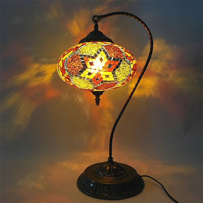 Lámpara decorativa de mesa de vidrio manchado de una cabeza de noche oblonga con brazo curvado en amarillo/azul/verde