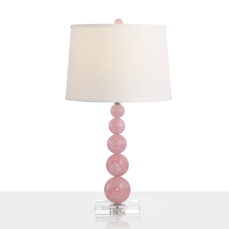 Lampada da comodino con paralume a botte Lampada da comodino bianca singola in tessuto modernista con supporto in vetro rosa con sfere